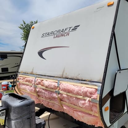 RV sidewall opened showing damaged insulation being removed